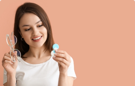 Mulher segurando um óculos e case de lentes de contato